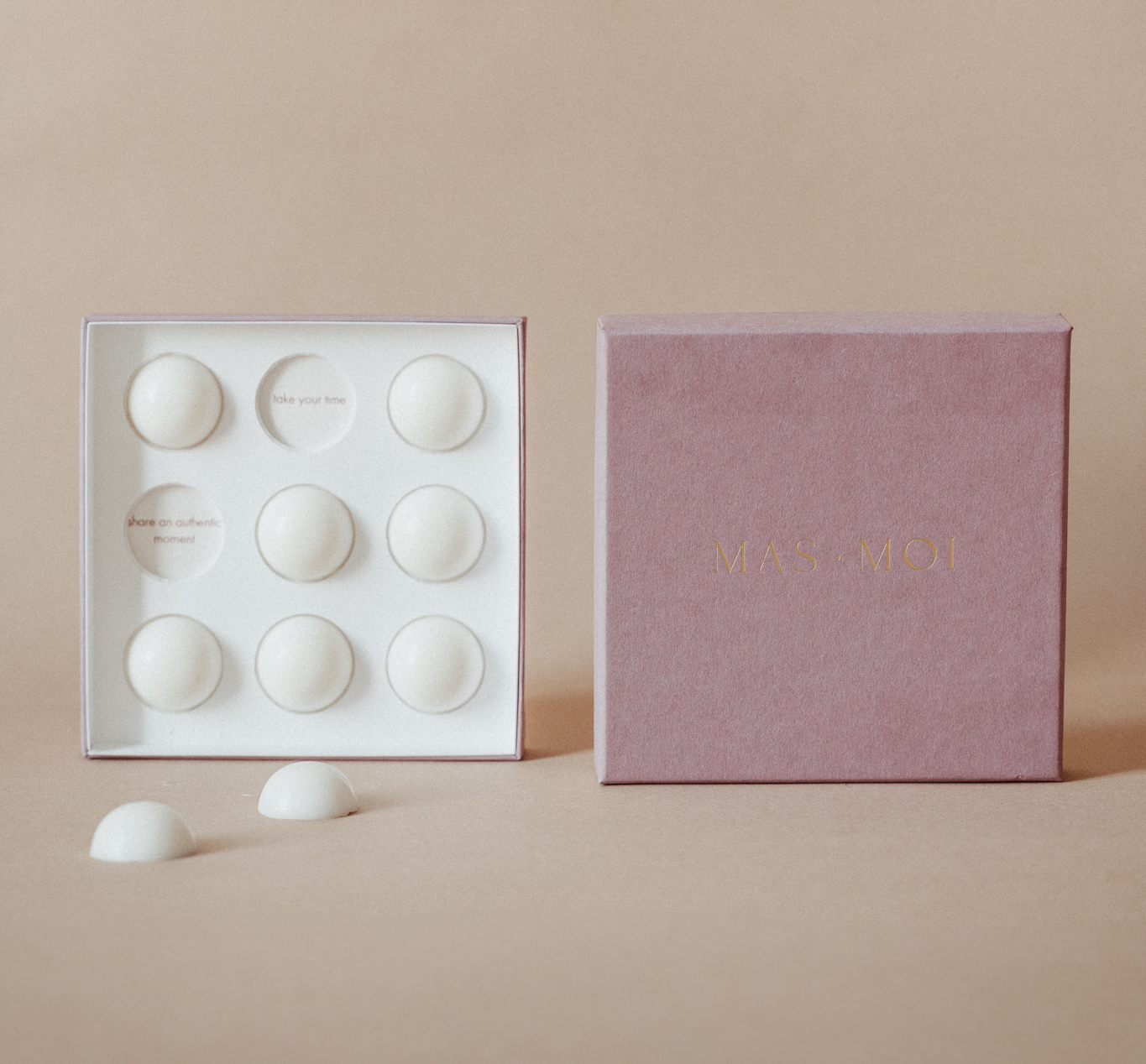 An open Masmoi box revealing Lavender Scent Massage Oil pearls inside, each designed to melt into nourishing oil for a soothing massage. The inner packaging includes playful text such as 'I got your back' and 'head goosebumps incoming,' adding a personalised touch. Set against a warm beige background, this luxurious product is perfect for a massage workshop or self-care ritual.